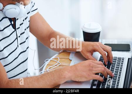 Die Geldmacher bei der Arbeit. Nahaufnahme eines Mannes, der auf einer Laptop-Tastatur tippt. Stockfoto