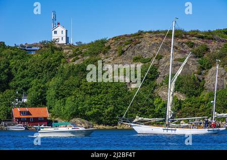 Malerische Küstenlandschaft mit Bootsverkehr und Bootsschuppen, Südküste von Nord-Koster-Insel, Bohuslän, Västra Götalands län, Schweden. Stockfoto