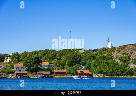 Malerische Küstenlandschaft mit Bootsschuppen und Hütten, Südküste von Nord-Koster-Insel, Bohuslän, Västra Götalands län, Schweden. Stockfoto