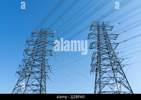 Hochspannungsleitung unter blauem Himmel Stockfoto