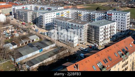 08. März 2022, Sachsen, Leipzig: Nach dem teilweisen Ausbau des Gerüsts sind die Neubauten der Leipziger Wohnungs- und Baugesellschaft (LWB) in der Saalfelder Straße erstmals richtig zu sehen. Die neue Wohnanlage mit 300 Wohnungen besteht aus 18 Häusern, die in sechs Blöcken um zwei Wohnhöfe angeordnet sind. Eine Tiefgarage bietet Platz für 170 Fahrzeuge. Voraussetzung für den Einzug ist eine Bescheinigung über die Wohnberechtigung. Nach zuletzt stagnierenden Zahlen hat sich der Sozialwohnungsbestand in Sachsen etwas erholt. (Luftaufnahme mit Drohne) P Stockfoto