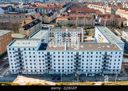 08. März 2022, Sachsen, Leipzig: Nach dem teilweisen Ausbau des Gerüsts sind die Neubauten der Leipziger Wohnungs- und Baugesellschaft (LWB) in der Saalfelder Straße erstmals richtig zu sehen. Die neue Wohnanlage mit 300 Wohnungen besteht aus 18 Häusern, die in sechs Blöcken um zwei Wohnhöfe angeordnet sind. Eine Tiefgarage bietet Platz für 170 Fahrzeuge. Voraussetzung für den Einzug ist eine Bescheinigung über die Wohnberechtigung. Nach zuletzt stagnierenden Zahlen hat sich der Sozialwohnungsbestand in Sachsen etwas erholt. (Luftaufnahme mit Drohne) P Stockfoto