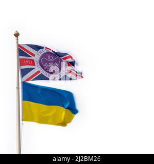 Die Platinum Jubilee Union Jack-Flagge, die auf einer Stange fliegt, zusammen mit der zweifarbigen Flagge der Ukrainischen Volksrepublik mit schlichtem, hellem Himmel dahinter Stockfoto