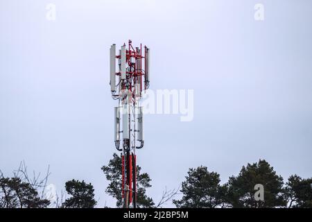 Handy und Internetzelle ragen über den Himmel. 5G Funkstrahlantennen. Stockfoto