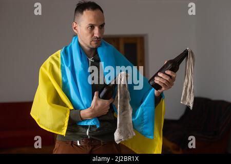 Mans Hand hält Molotov Cocktailflasche. Minimales Ukraine-Konzept. Stockfoto