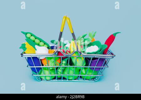 Verschiedene Weichmachergemüse in einem Warenkorb auf blauem Hintergrund. Gesunde Ernährung, Antioxidantien, Gesundheit. Stockfoto