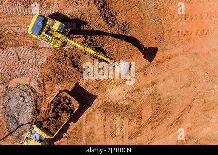 Luftaufnahme eines Baggers, der die Erde in einen Muldenkipper ladet Stockfoto