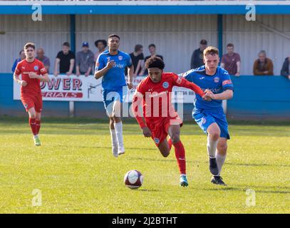 Rylands-Spieler läuft in einem Spiel im Harry Williams Riverside Stadium vor einem Verteidiger von Ramsbottom Stockfoto