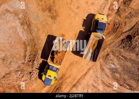 Luftaufnahme von oben auf der Baustelle von der Erde bewegenden schweren Geräten Stockfoto