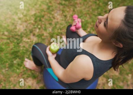 Für ihr Baby in Form bleiben. Aufnahme einer jungen Schwangeren, die draußen trainiert. Stockfoto