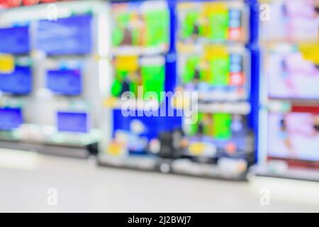 Eletronisches Kaufhaus mit verschwommenen Fernsehregalen im Hintergrund Stockfoto