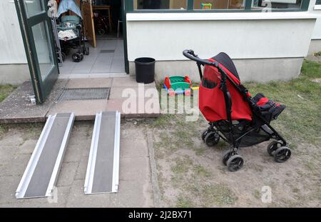 Schwerin, Deutschland. 31. März 2022. Vor einem Bungalow im AWO-Feriendorf Muess steht ein Kinderwagen, in dem Flüchtlinge aus der Ukraine untergebracht sind. Manuela Schwesig (SPD), Ministerpräsidentin von Mecklenburg-Vorpommern, erfuhr bei ihrem Besuch bei den ukrainischen Flüchtlingen von der Lage im Feriendorf. Quelle: Bernd Wüstneck/dpa-Zentralbild/dpa/Alamy Live News Stockfoto