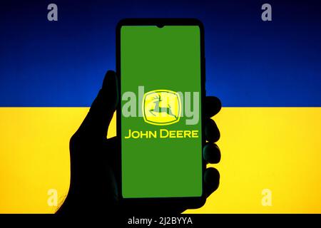 Spanien. 23. März 2022. In dieser Abbildung ist ein John Deere-Logo auf einem Smartphone mit einer ukrainischen Flagge im Hintergrund zu sehen. (Bild: © Thiago Prudencio/SOPA Images via ZUMA Press Wire) Stockfoto