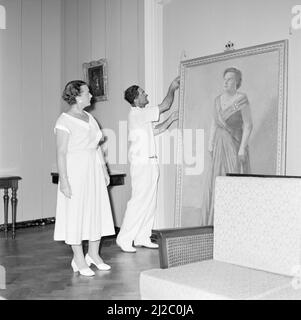 Die Hängung eines Staatsporträts von Königin Juliana in der königlichen Residenz in Fort Amsterdam in Willemstad unter dem wachsamen Auge der Gattin des Gouverneurs, Frau Struycken-Feldbrugge, ca. Oktober 1955 Stockfoto