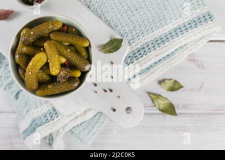 Eingelegte Gurken, Gewürze und Knoblauch auf weißem Holztisch konservieren Stockfoto
