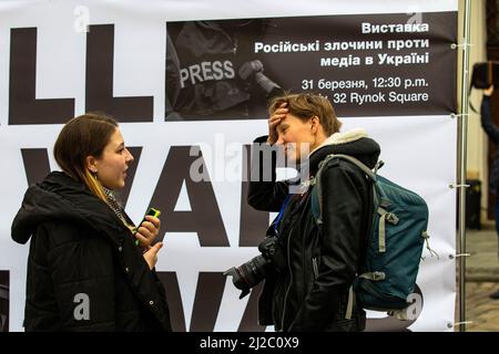 Lviv, Ukraine. 31. März 2022. Zwei Reporterinnen nehmen an der Pressedenkstätte Teil. In Lemberg wurde ein temporäres Denkmal errichtet, um an die Pressevertreter zu erinnern, die im russisch-ukrainischen Krieg getötet wurden. Kredit: SOPA Images Limited/Alamy Live Nachrichten Stockfoto