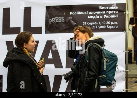 Lviv, Ukraine. 31. März 2022. Zwei Reporterinnen nehmen an der Pressedenkstätte Teil. In Lemberg wurde ein temporäres Denkmal errichtet, um an die Pressevertreter zu erinnern, die im russisch-ukrainischen Krieg getötet wurden. (Foto von Ty ONeil/SOPA Images/Sipa USA) Quelle: SIPA USA/Alamy Live News Stockfoto