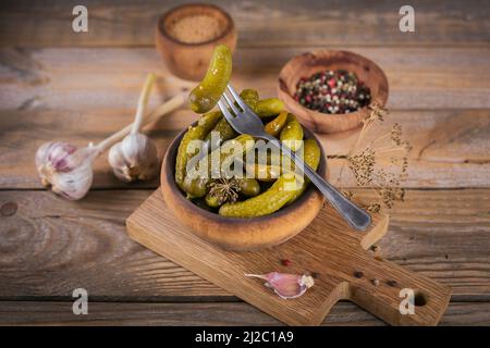 Eingelegte Gurken, Gewürze und Knoblauch auf Holztisch konservieren Stockfoto