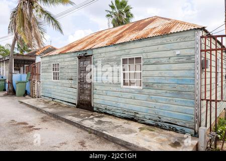 Kleines Haus mit verwitterter Fassade und rostigen Dach in den Vororten von Willemstad, Curacao Stockfoto