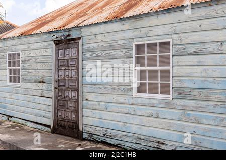 Kleines Haus mit verwitterter Fassade und rostigen Dach in den Vororten von Willemstad, Curacao Stockfoto