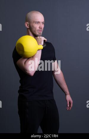 Kerl mit einem gelben Kettlebell-Fitnessstudio anonyme junge Stärke, für den sportlichen Lifestyle für starke und Boden Sportbekleidung, vietnamese filipino. Gesunder Daunen Stockfoto