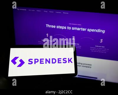 Person, die Mobiltelefon mit dem Logo des französischen Fintech-Unternehmens Spendesk SAS auf dem Bildschirm vor der Business-Webseite hält. Konzentrieren Sie sich auf die Telefonanzeige. Stockfoto