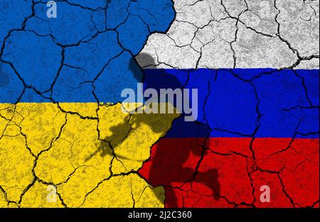 Zerbrochene Beziehungen zwischen Russland und der Ukraine mit Länderflaggen und Schatten eines Soldaten im Krieg. Stockfoto