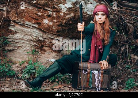 Outdoor-Porträt einer jungen Frau im Piratenkostüm mit einem Schwert. Stockfoto