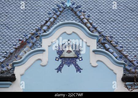 Das Auge der Vorsehung in der Nordfassade der Kirche St. Elisabeth (Kostol svätej Alžbety), die gemeinhin als Blaue Kirche (Modrý kostolík) in Bratislava, Slowakei, bekannt ist. Die vom ungarischen Architekten Ödön Lechner entworfene Kirche wurde zwischen 1909 und 1913 im ungarischen sezessionistischen Stil erbaut. Stockfoto