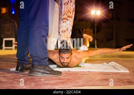 Schauspieler Fakir Stuntman liegt auf zerbrochenem Glas Stockfoto