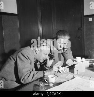 Regisseur Gerard Rutten und Produzent Bobby Roosenboom überprüfen ein Model im Cinetone-Omo Studio Ca. 10. Dezember 1953 Stockfoto