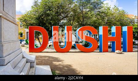 DUSHI in großen roten und blauen Buchstaben im Stadtzentrum von Willemstad geschrieben Stockfoto