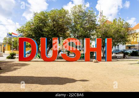 DUSHI in großen roten und blauen Buchstaben im Stadtzentrum von Willemstad geschrieben Stockfoto