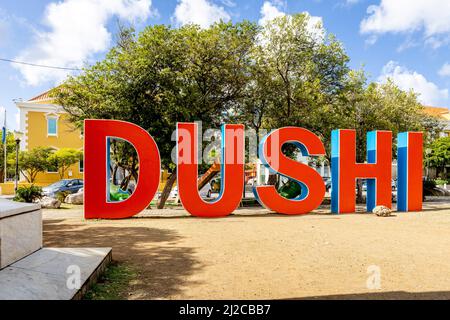 DUSHI in großen roten und blauen Buchstaben im Stadtzentrum von Willemstad geschrieben Stockfoto