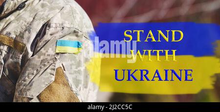 Ukrainische Flagge mit Kopierraum und Textstand mit Ukraine. Ukrainische Flagge auf Militäruniform. Stoppt die russische Aggression. Beendet den Krieg in der Ukraine. Bleiben Sie in der Ukraine. Sensation. Betet für die Ukraine Stockfoto