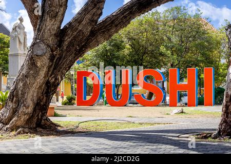 DUSHI in großen roten und blauen Buchstaben im Stadtzentrum von Willemstad geschrieben Stockfoto