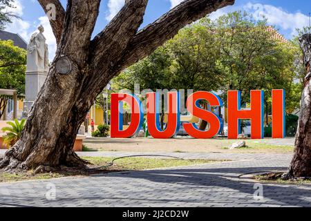 DUSHI in großen roten und blauen Buchstaben im Stadtzentrum von Willemstad geschrieben Stockfoto