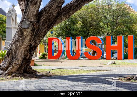 DUSHI in großen roten und blauen Buchstaben im Stadtzentrum von Willemstad geschrieben Stockfoto