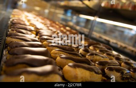 Sehr frischer Eclare-Kuchen auf der Theke in der Bäckerei Stockfoto