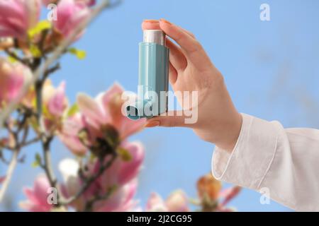 Junge Frau mit Inhalator im Freien am Frühlingstag, Nahaufnahme Stockfoto