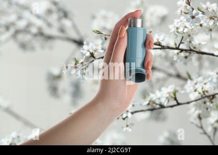 Junge Frau mit Inhalator im Freien am Frühlingstag, Nahaufnahme Stockfoto