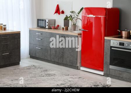Roter Retro-Kühlschrank und moderne Arbeitsflächen in der Küche Stockfoto