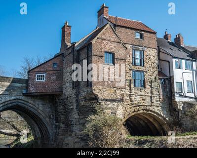 Farbenfrohe Szenen auf dem Fluss tragen sich in der historischen Stadt Durham, die hier mit Blick auf die ursprünglichen Bögen der Elves Bridge gezeigt wird Stockfoto