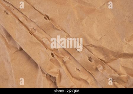 Zerkleinerte leere Verpackung. Zerrissenes, zerknittert verpacktes Material. Faltiges braunes Papier. Abstrakter Hintergrund Stockfoto