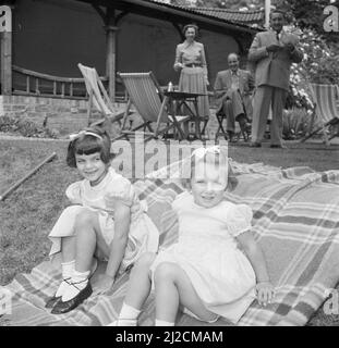 Zwei Mädchen der Familie Martineau, im Garten der Old Lodge in Terlow, Buckinghamshire, spielen Krocket. Im Hintergrund der Künstler Eppo Doeve ca.: Juli 1954 Stockfoto