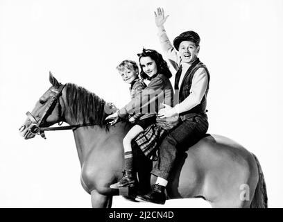 Promo Still für den Film National Velvet aus dem Jahr 1944. Von links nach rechts, sitzend auf einem Modell eines Pferdes: Jackie 'Butch' Jenkins, Elizabeth Taylor und Mickey Rooney Stockfoto