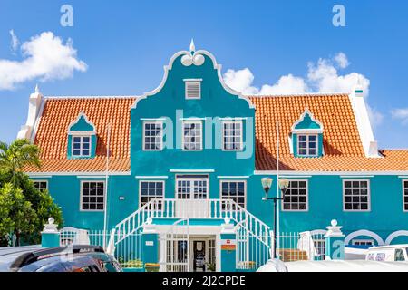 Schönes Gebäude mit türkisfarbener Fassade, weißen Details und einem orangefarbenen Dach in Willemstad, Curacao Stockfoto