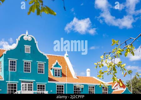 Schönes Gebäude mit türkisfarbener Fassade, weißen Details und einem orangefarbenen Dach in Willemstad, Curacao Stockfoto