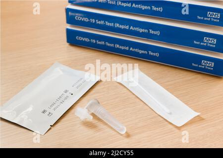 VEREINIGTES KÖNIGREICH - 26. März 2022. Stapel von Boxen für seitliche Durchflussprüfung mit Inhalt, Covid-19 NHS Test und Trace, Großbritannien Stockfoto