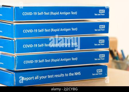 VEREINIGTES KÖNIGREICH - 26. März 2022. COVID-19 Selbsttest (Rapid Antigen Test), NHS-Trace und -Test. Stapel von Covid-LFT-Tests, Testkits, Boxen, NHS-Trace Stockfoto